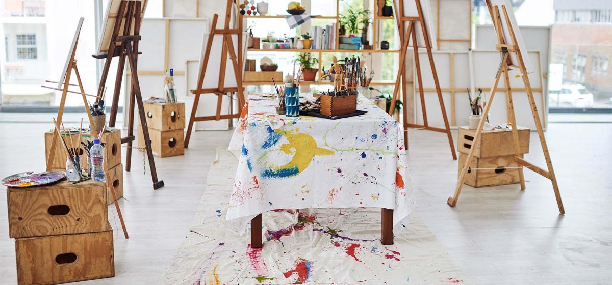 Artist's studio with bright paint splattered over table