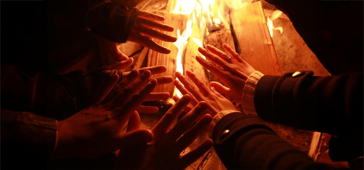 Hands around a fire