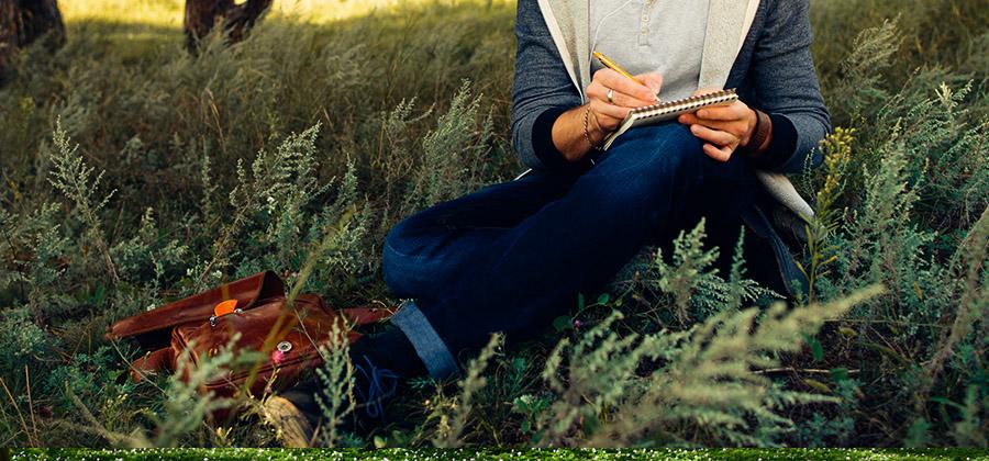 Person writing in the woods