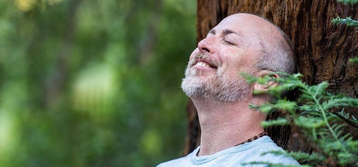 Scott Schwenk meditating by a tree