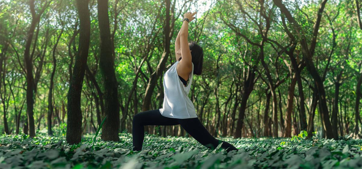 Woman in warrior pose in the woods