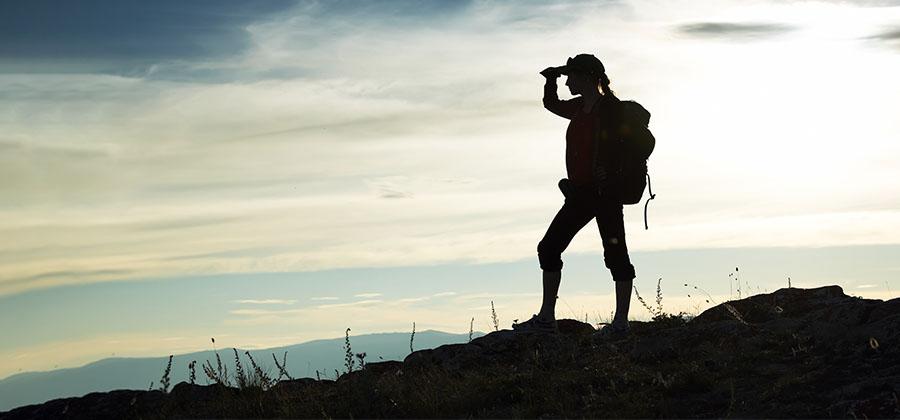 Woman looking off into the distance on a mountaintop