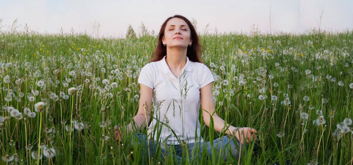 woman practicing yoga in a field