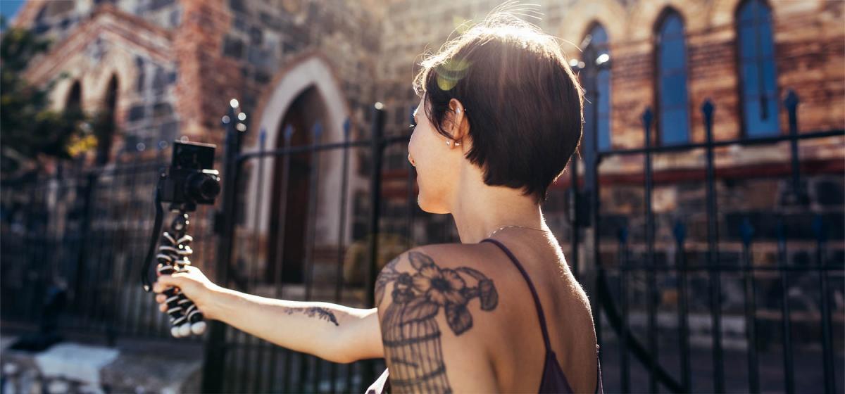 Social media influencer filming a video outside a historic building