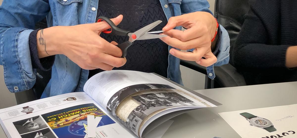 Person making a collage from magazine images