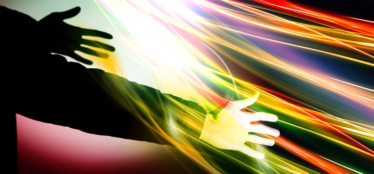 Hands in a vortex of colored light