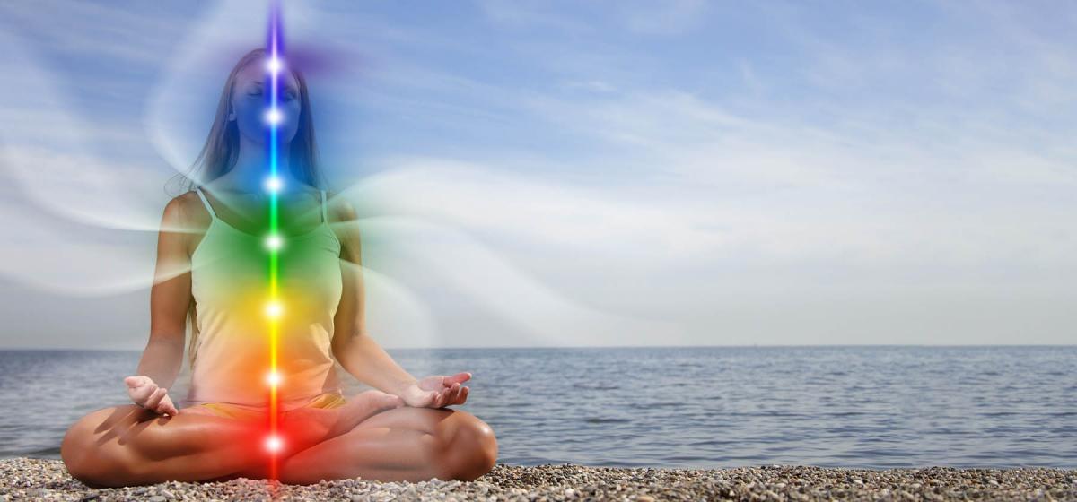 Woman on beach with rainbow chakras