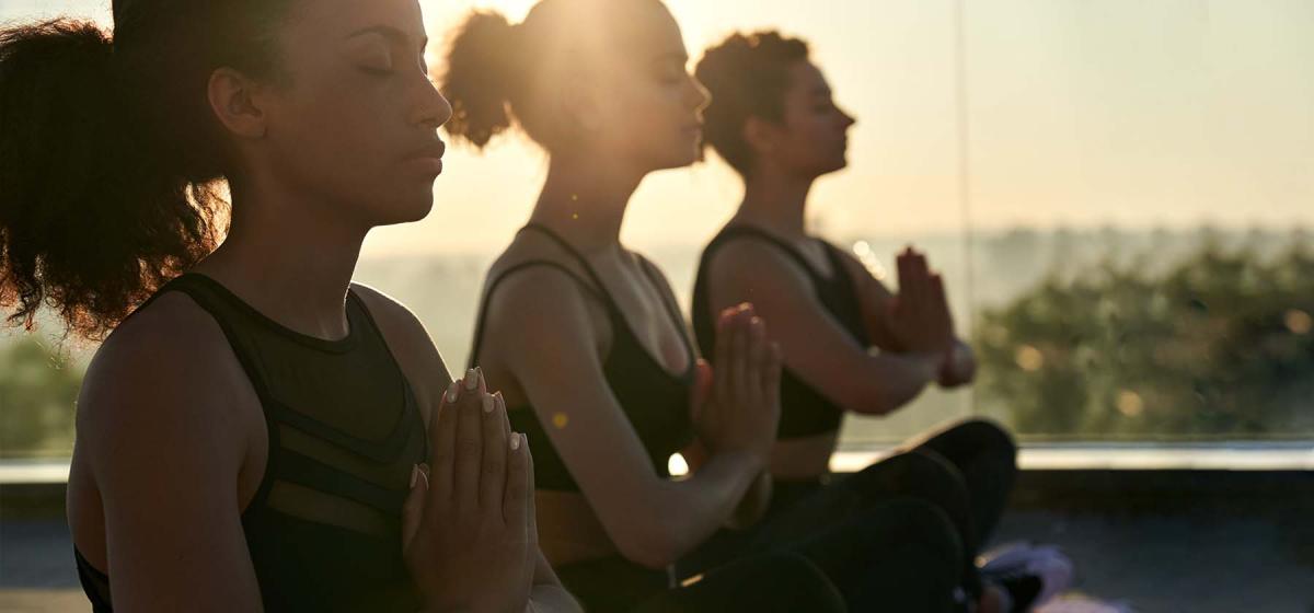 People in yoga class outside at sunset