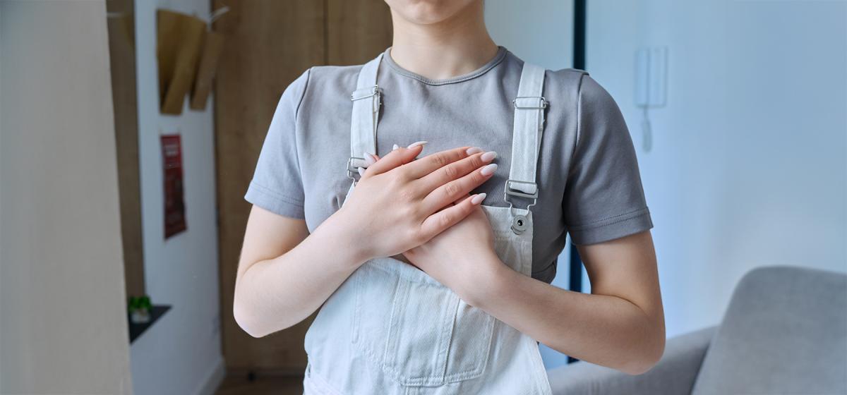 Person with hands over heart in gratitude