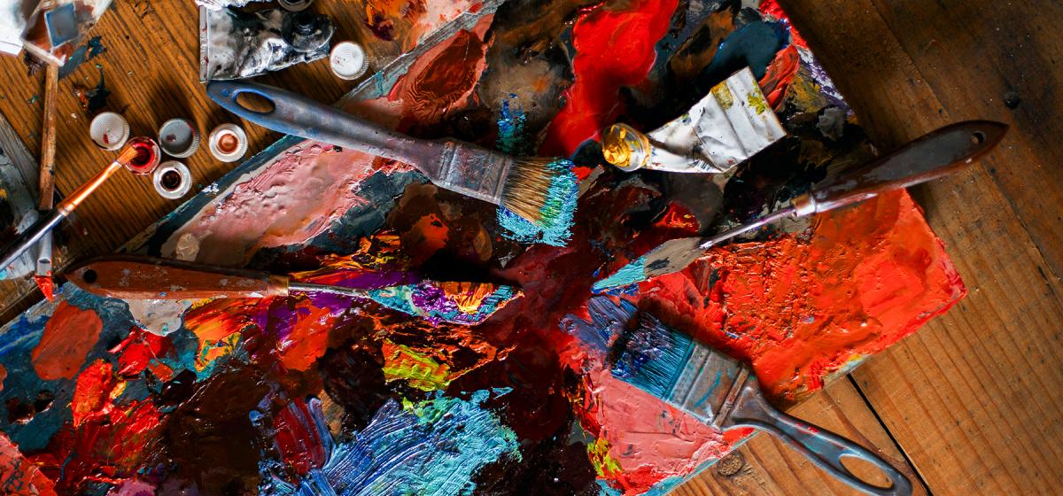 Artist's paint palette and brushes, with bright red and blue paint