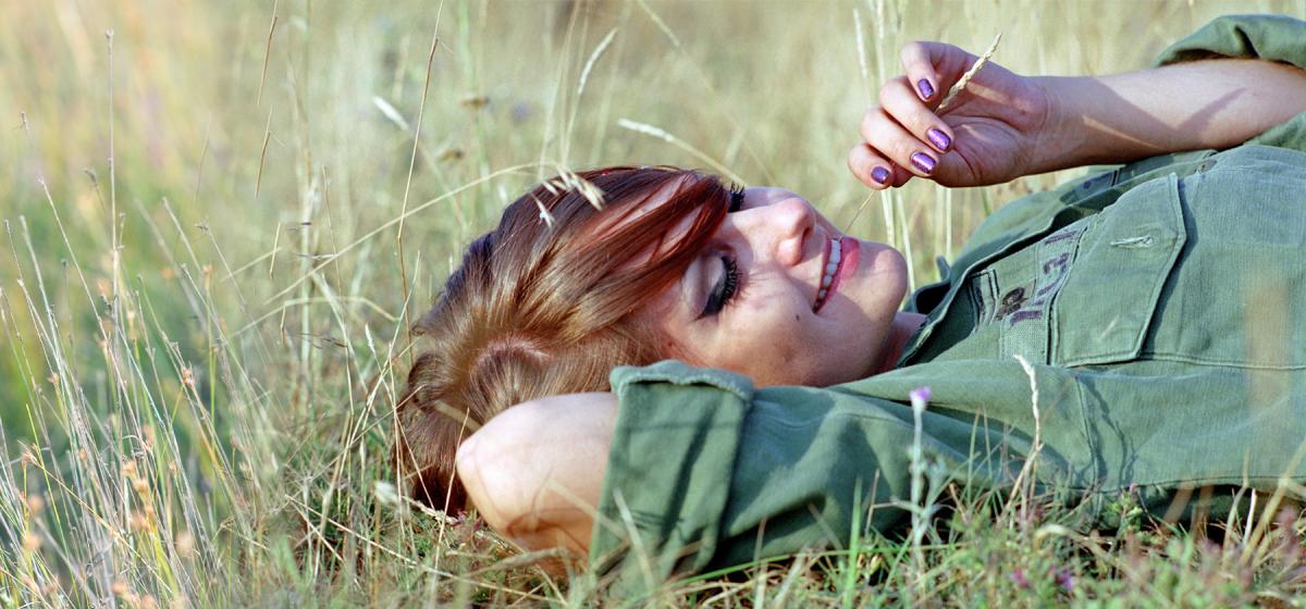 Woman laying in the grass meditatively