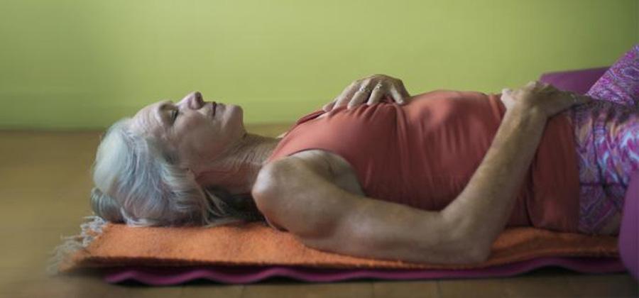 Woman laying on a yoga mat in yoga nidra