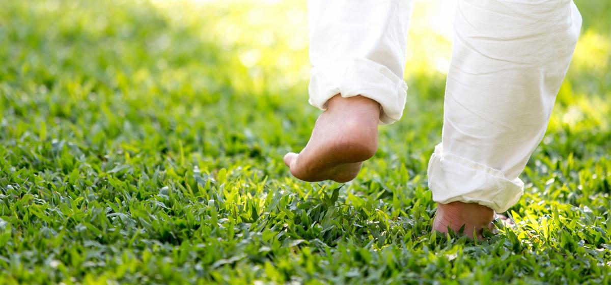 Person walking meditatively in the grass