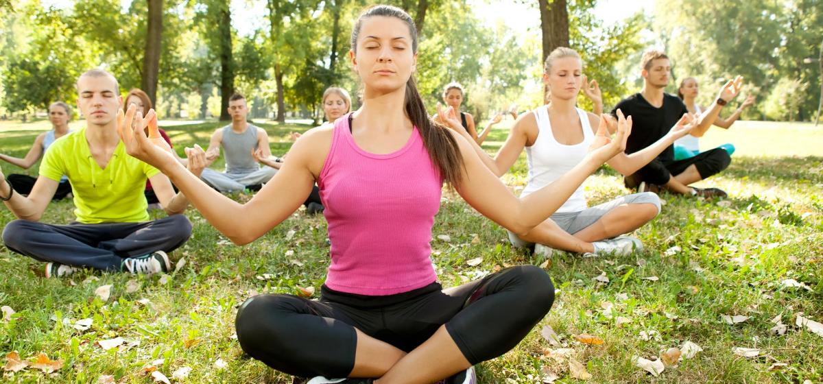 Group of people meditating in a park
