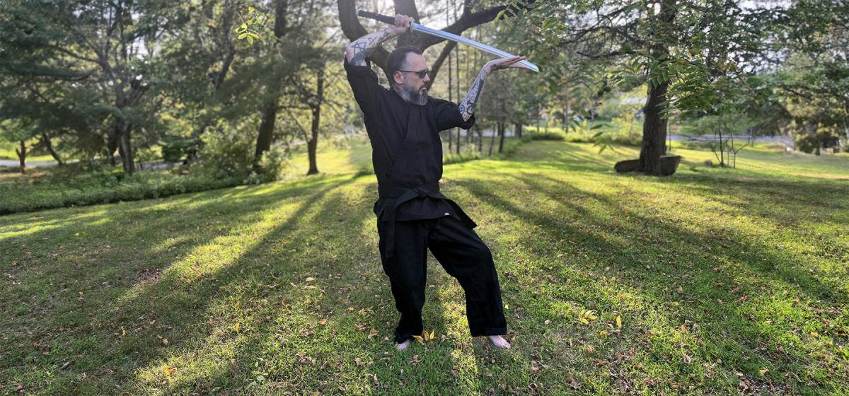 Damien Echols practicing sword arts outside in a field