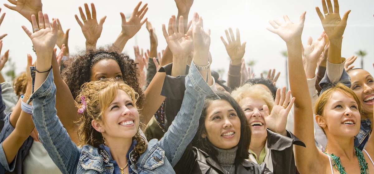 Group of women with hands raised in the air