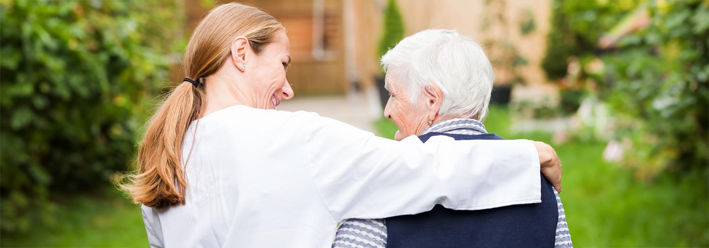 Elderly person and their caregiver in a park