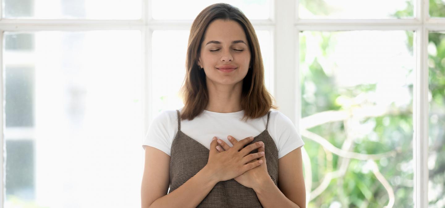 Woman smiling and appearing grateful.