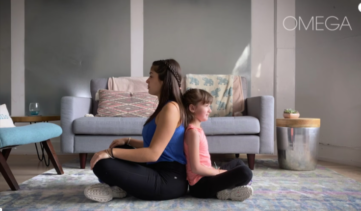 Woman and child sitting back-to-back