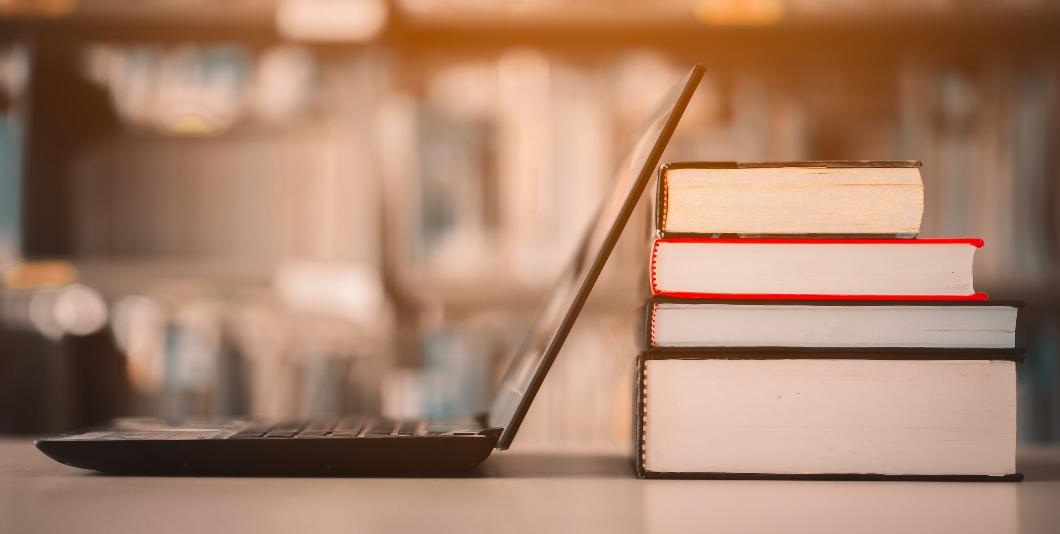 Computer next to stack of books