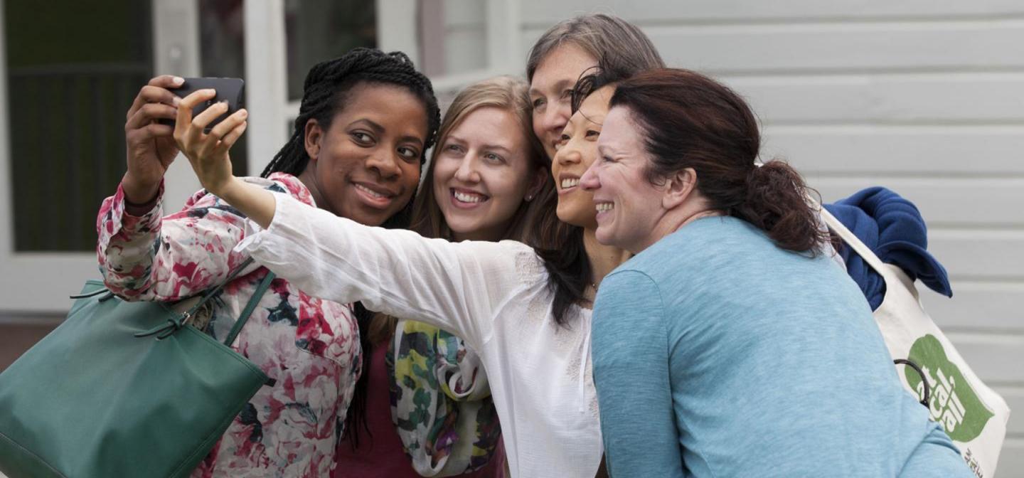 Group of women over 40 smiling and taking a selfie, representing empowerment, community, and support through menopause and midlife transitions.
