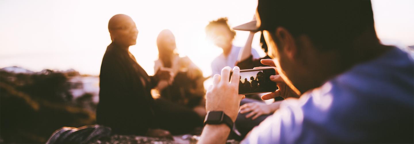 Documentary filmmaker recording people at sunset, representing mindfulness, observation, and conscious seeing.