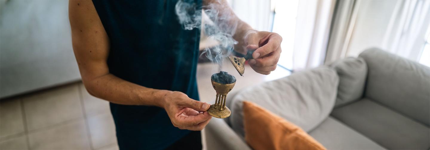 Person using incense to cleanse a room as part of a limpia ritual