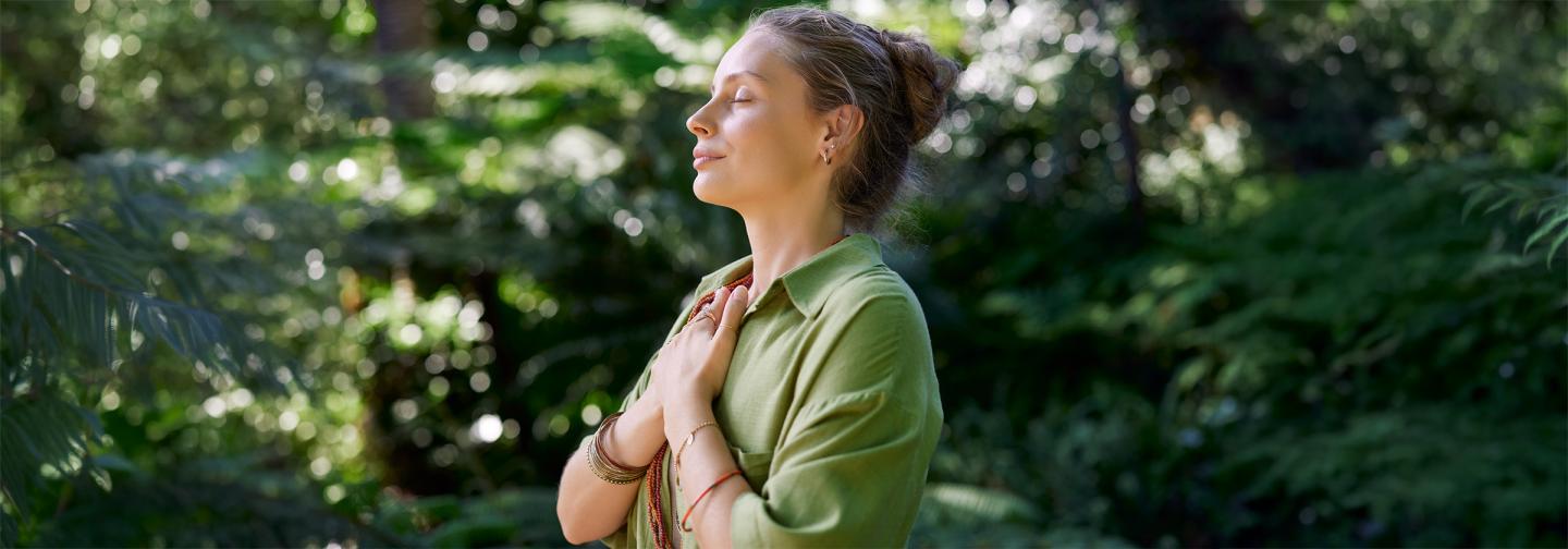 Woman practicing mindful breathing outdoors illustrating natural foot pain relief through breathwork, gentle movement, and holistic physical therapy practices