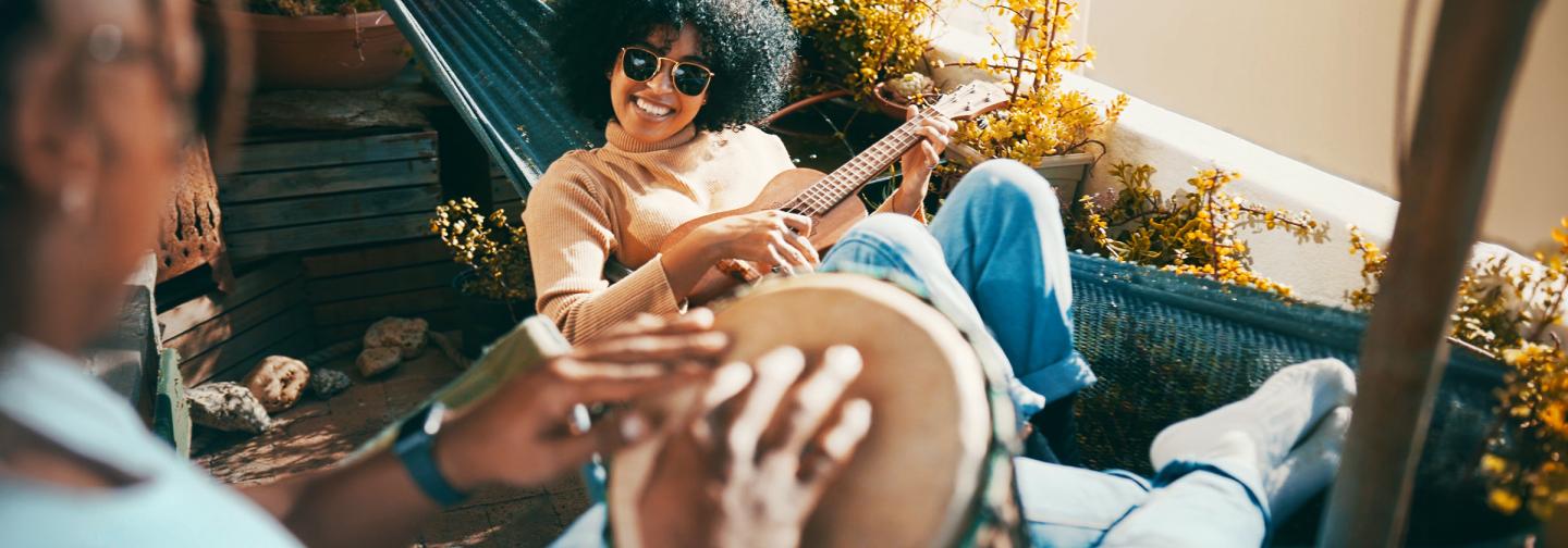 Participants playing guitar and hand drum together during a music retreat celebrating creativity, community, songwriting, and the healing power of music.