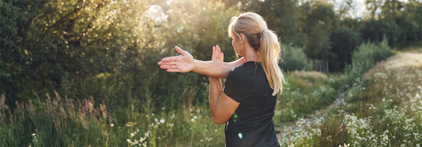 Woman doing a mindful movement exercise outdoors in a field