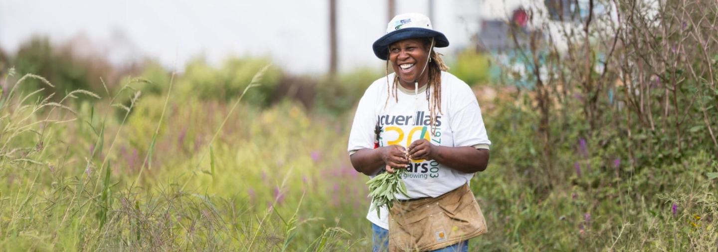 Karen Washington harvesting sage in a field, as part of a sustainability workshop