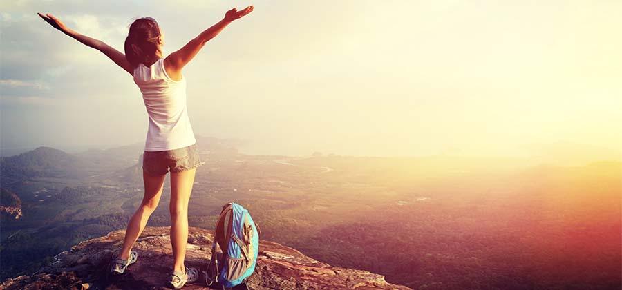 Woman standing on a mountain with her backpack