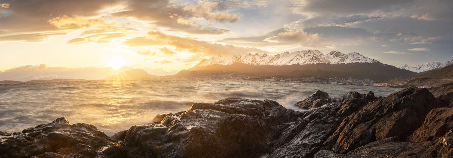 Rocky coastline and open sea at sunset, evoking the epic journey and homecoming of Homer’s The Odyssey.