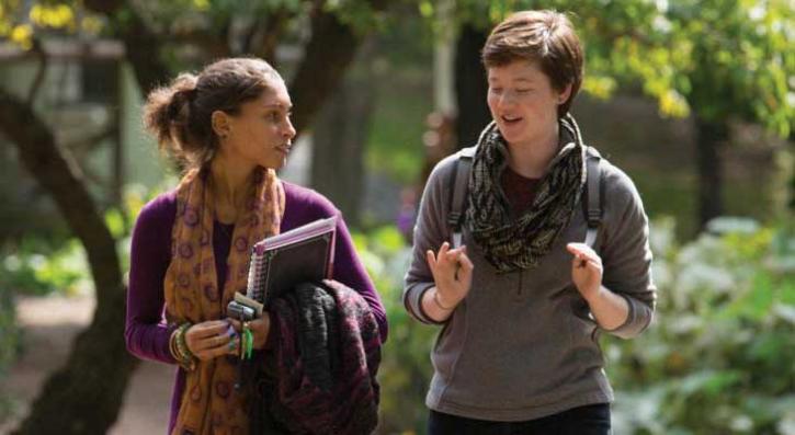 2 women chatting while walking through campus