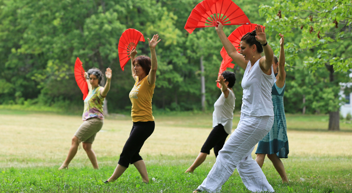 women dancing with red fans