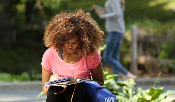 Young woman with fabulous hair write in a journal